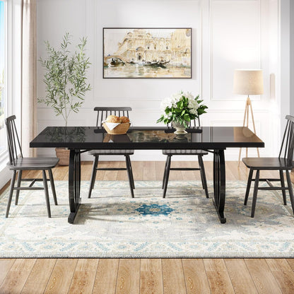 Dining room with a black table and chairs on a patterned rug.