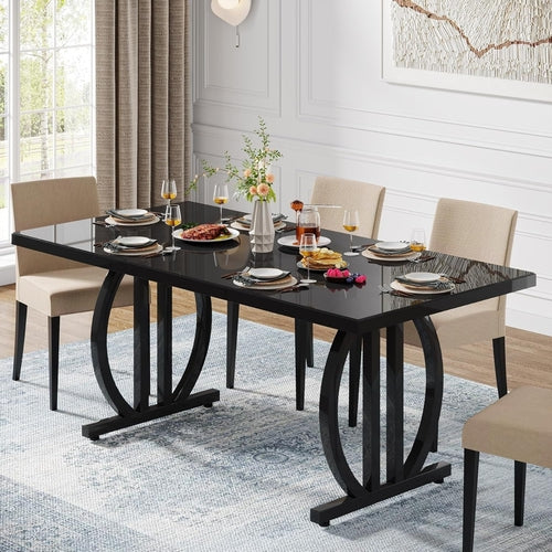 Dining room with a black glass table and beige chairs, set for a meal.