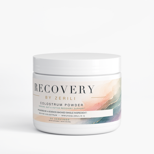 A white plastic jar of Recovery by Zerili Colostrum Powder with a white lid, featuring a label with a soft pastel watercolor design in peach, pink, and teal on a clean white background.