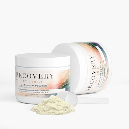 Two white jars of Recovery by Zerili Colostrum Powder with a small scoop and a pile of the powder in front, set against a clean white background.