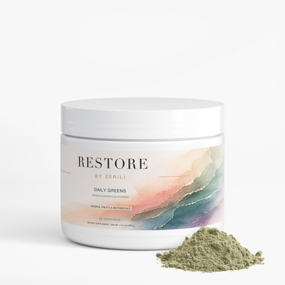 Restore by Zerili Daily Greens tub beside a small pile of green superfood powder.