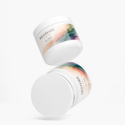 Two Restore by Zerili Daily Greens supplement tubs shown floating at different angles on a light background.
