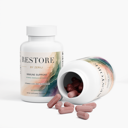 Two Restore by Zerili Immune Support bottles, one open on its side with pink capsules spilling out.